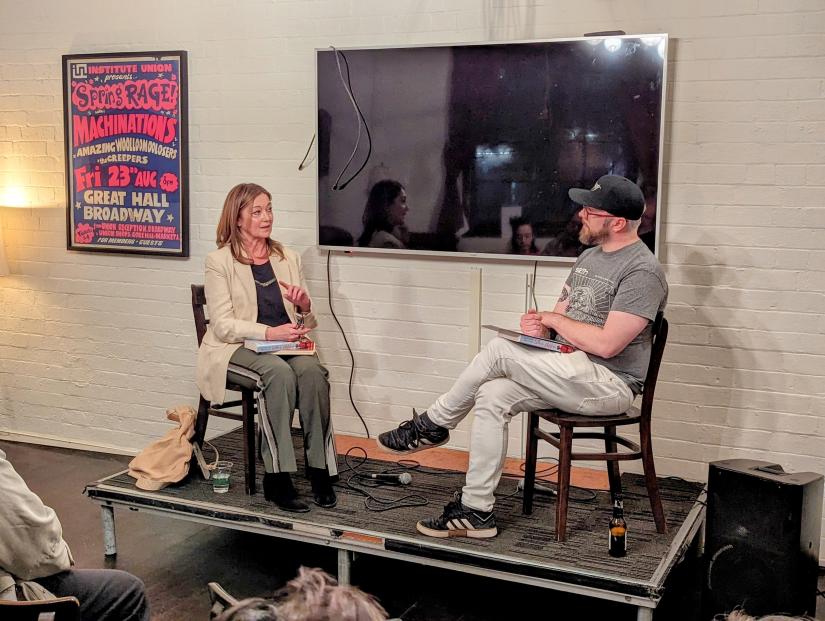 A woman and man speak on stage