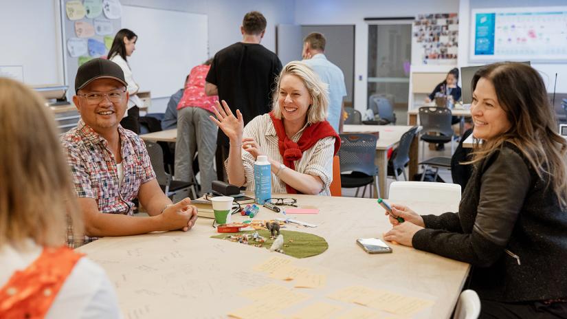 People sitting around a table working together on a creative exercise