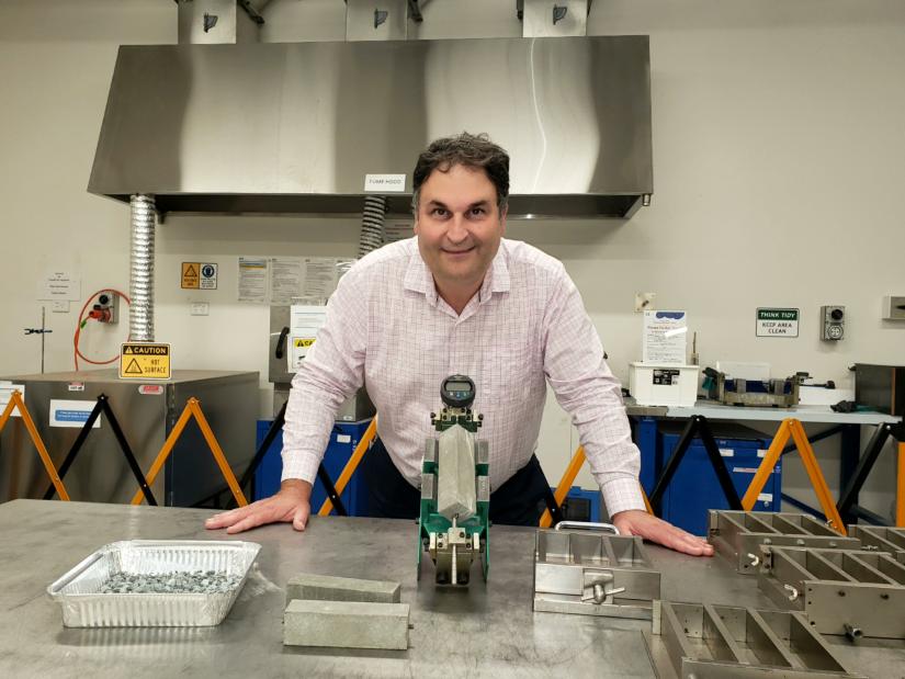 A/Prof. Kirk Vessalas standing at table in lab