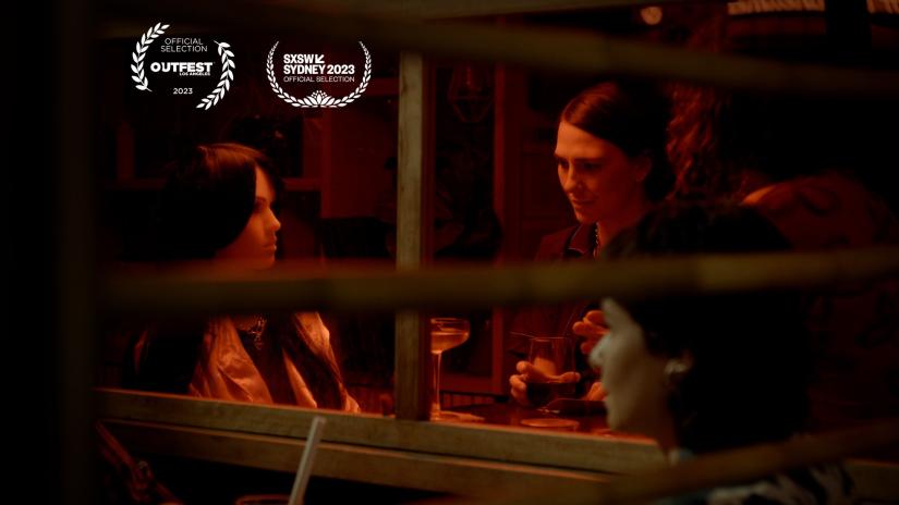 A still of a woman sitting at a dinner table with a doll