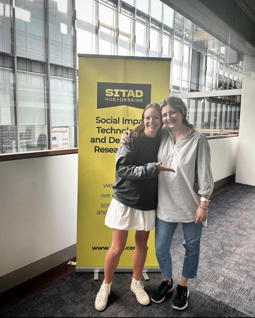 Olga and Daryna stand arm-in-arm and smile for the camera