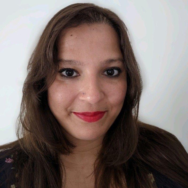 A selfie of Andy, who smiles at the camera and is wearing lipstick