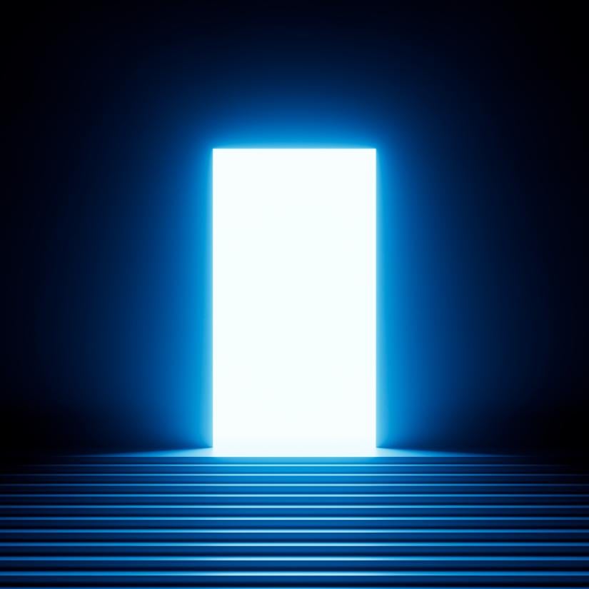 A dark hallway illuminated by light emanating from an open door