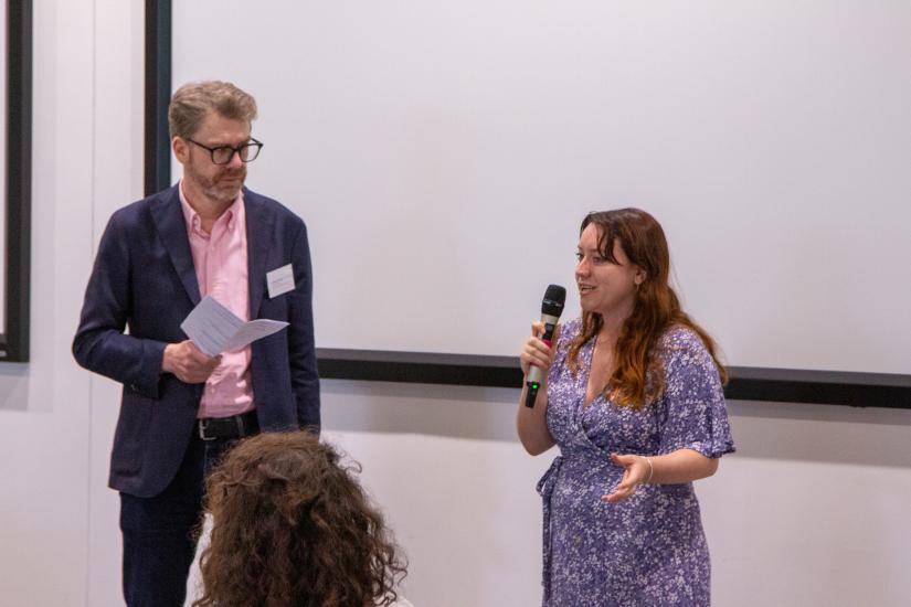 A man and a woman speak to a crowd of students