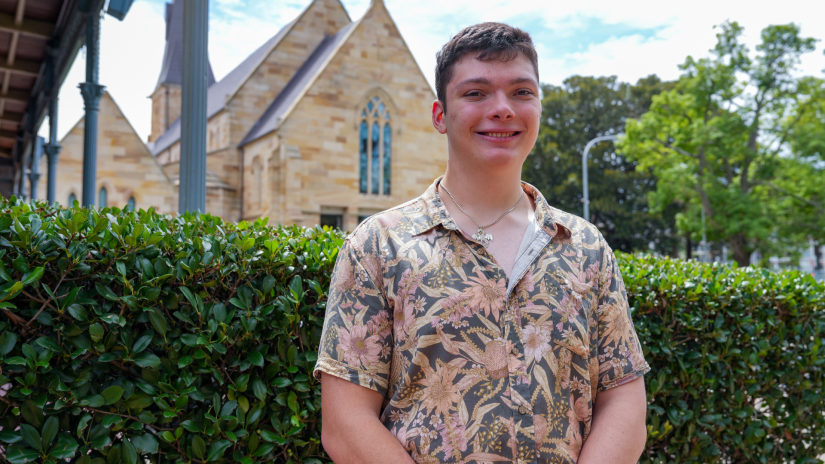 Student smiling in front of a church building.