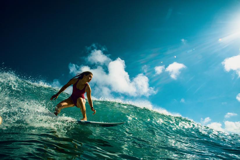 Stock picture of a professional female surfer in action, riding a wave. Picture: willyam/Adobe Stock