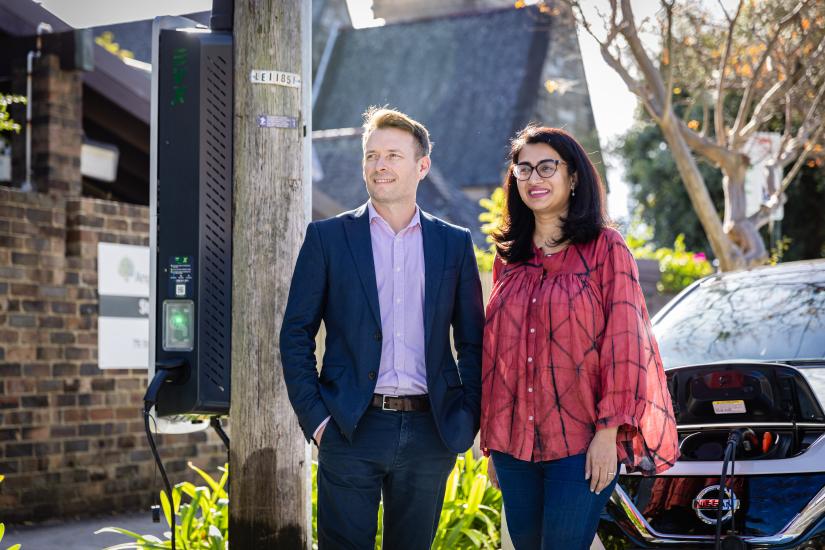 Dr Scott Dwyer and Kriti Nagrath posing infront of an EV charging station.
