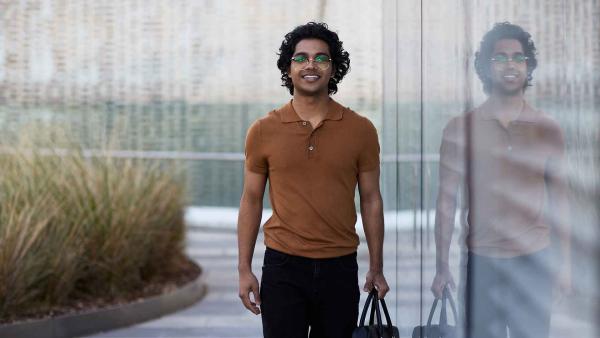 Young man carrying a briefcase walks along the balcony of the University of Technology Sydney Library