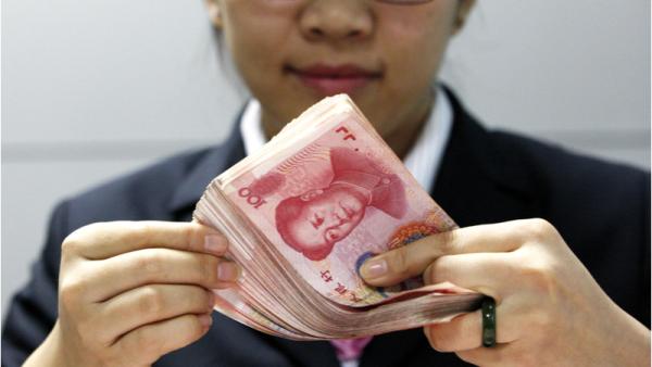 800x450%20A%20Chinese%20clerk%20counts%20RMB%20yuan%20banknotes