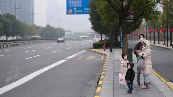 800x450%20A%20family%20wearing%20surgical%20masks%20waiting%20at%20bus%20station