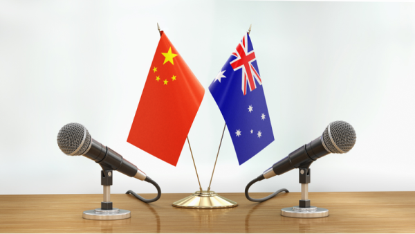 800x450%20Microphones%20and%20AU%20CN%20flags%20pair%20on%20a%20desk_0