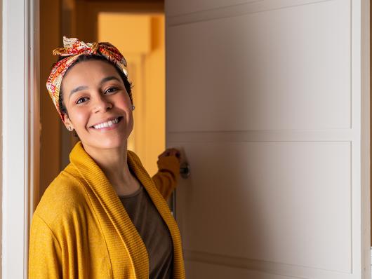 Stock image of a close up of smiling woman with head band leaving home during the day.