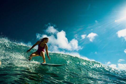 Stock picture of a professional female surfer in action, riding a wave. Picture: willyam/Adobe Stock