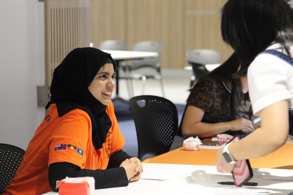 A Peer Networker smiling at a student during event registration.