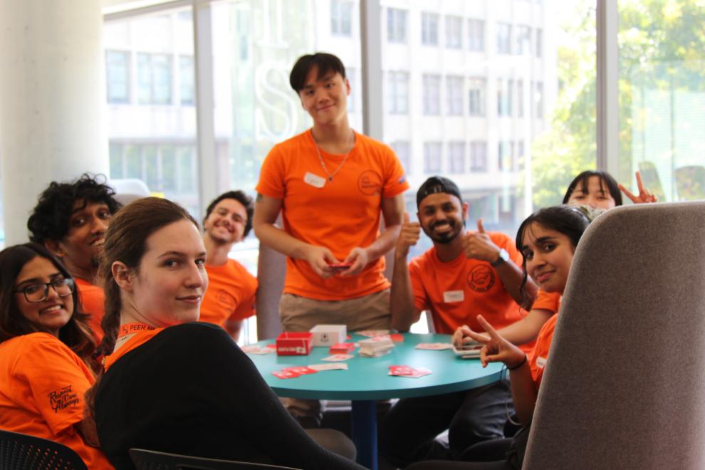 A group of PNs smiling at the camera whilst playing cards.