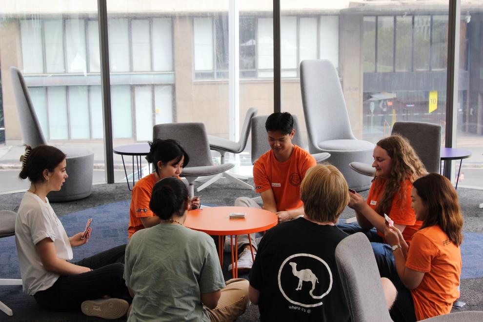 Four Peer Networkers playing cards with students.