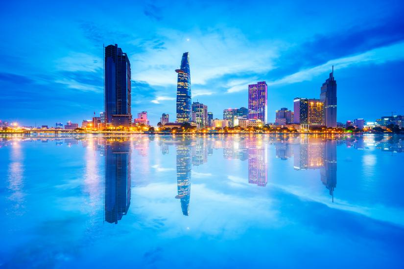 Reflection of Night view of Business District and Administrative Center of Ho Chi Minh city on Saigon riverbank.