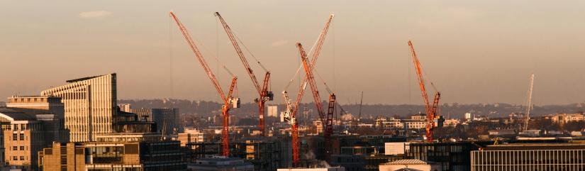 Cranes on top of buildings.