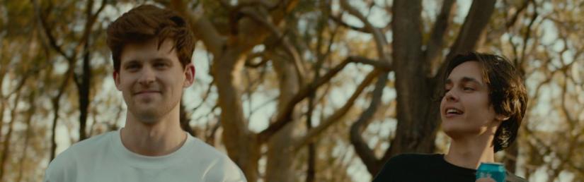 Still from The Trip with two men speaking to each other in front of trees