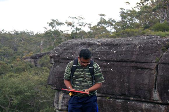 PhD student Buddhi Dayananda in the field at Morton National Park