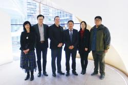 A group of six people standing by the UTS Double Helix Staircase.