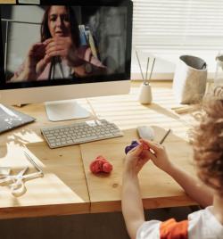 Photo Of Kid Playing With Clay While Looking In The Monitor