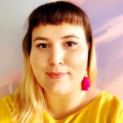 A selfie of Bonnie, smiling with brown and blonde hair and pink earrings