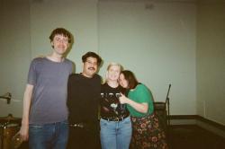 Four people standing together smiling at the camera