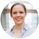 Isabelle Schaefer is wearing a striped shirt. Her hair is tied back and she is smiling at the camera.