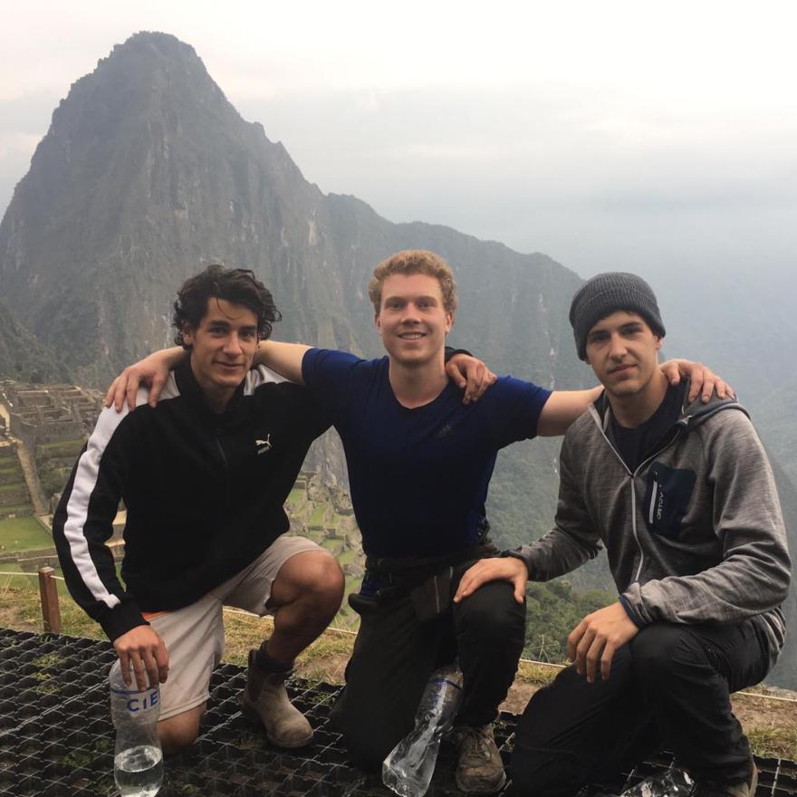 Three students sitting on top of mountain
