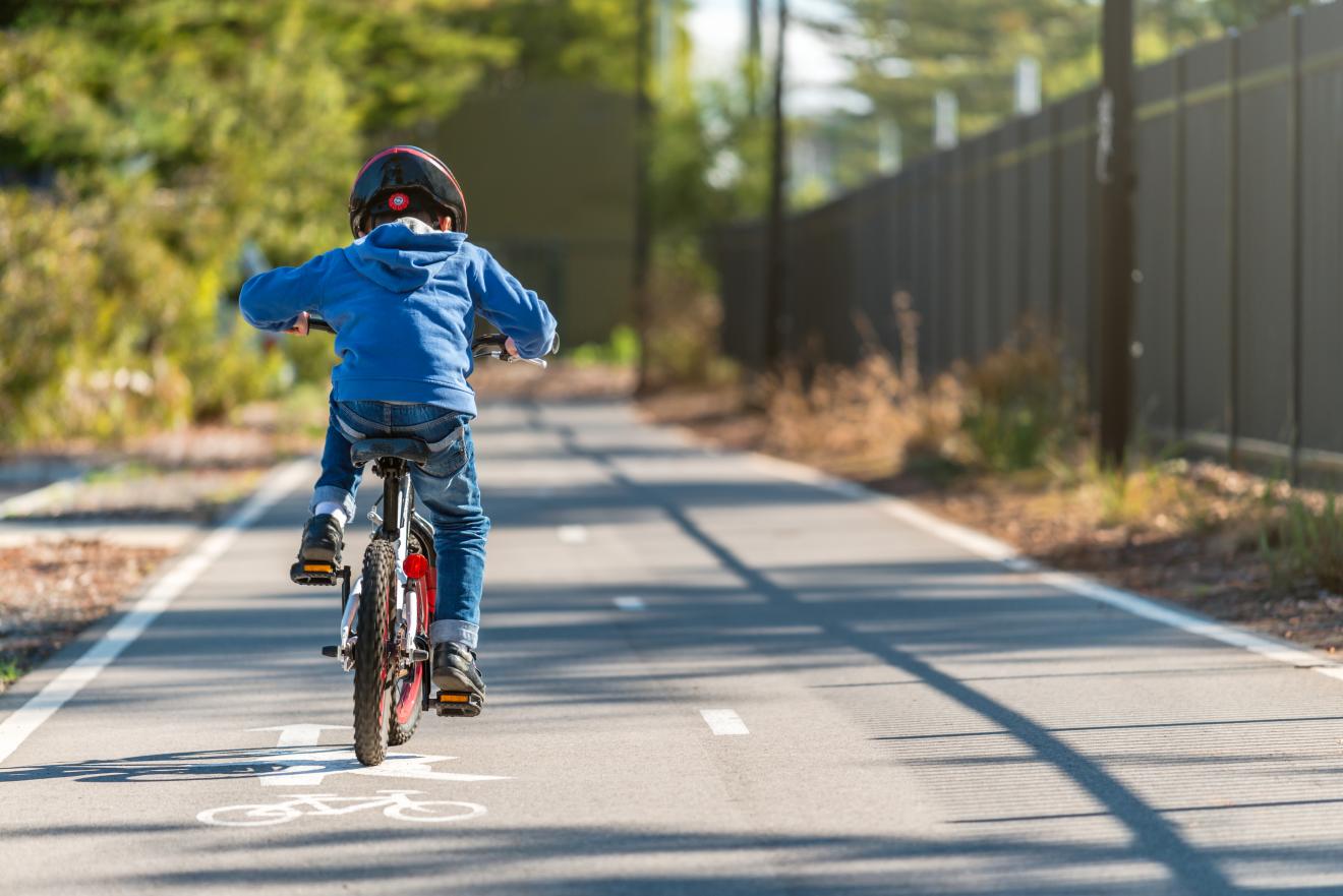 Young boy riding bike on a path