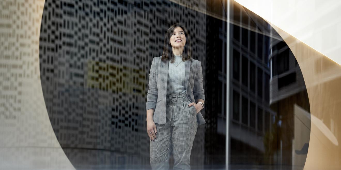 Woman in a suit looking out a glass window