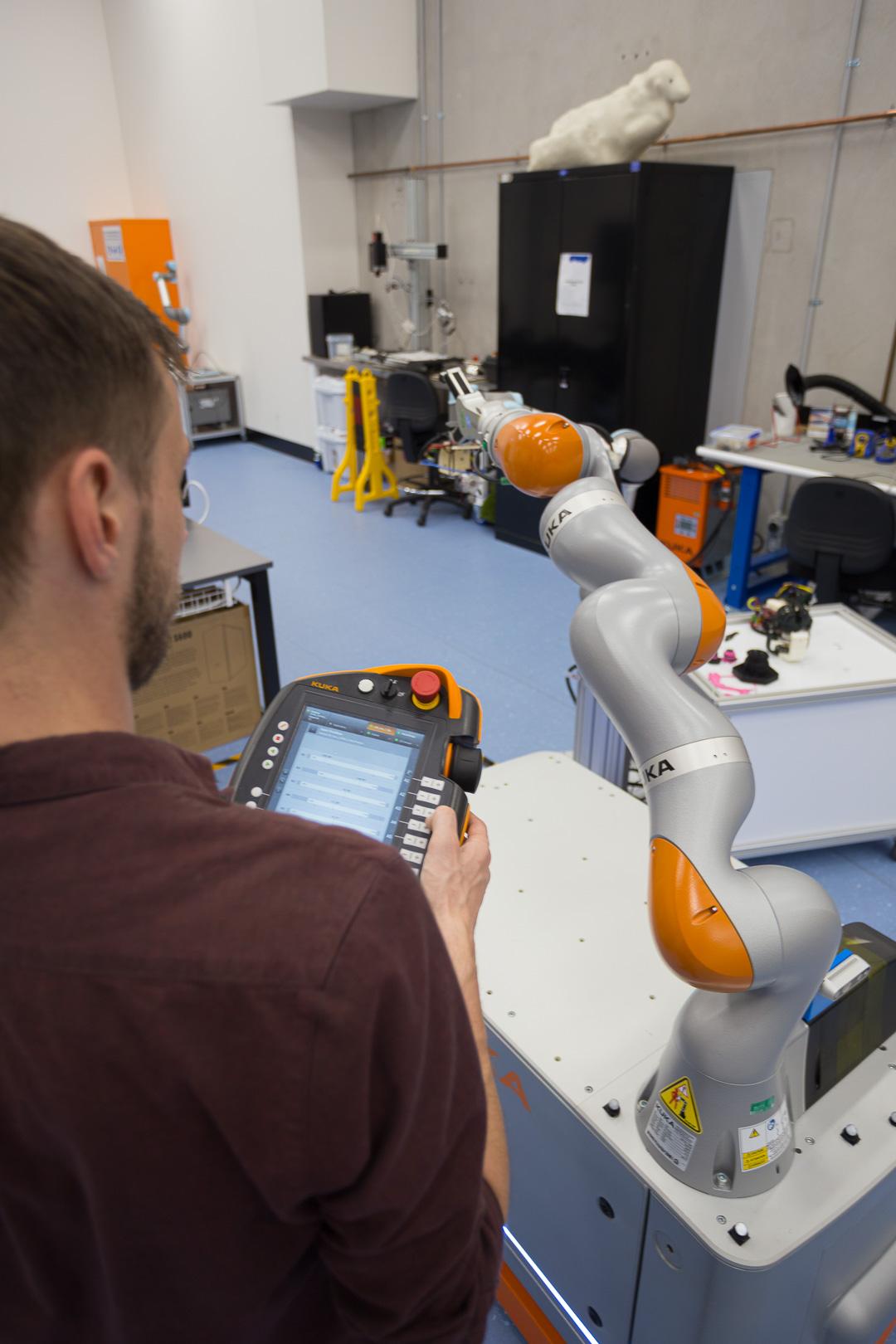 A researcher programs a robot arm to move.