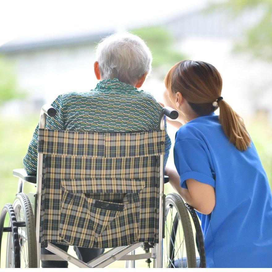 Health professional talking to elderly man in wheelchair