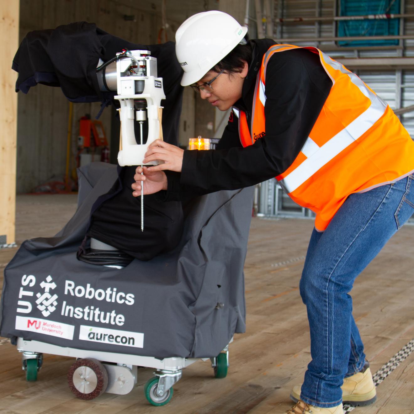 UTS researcher fits a screw into a robot on a Perth construction site.