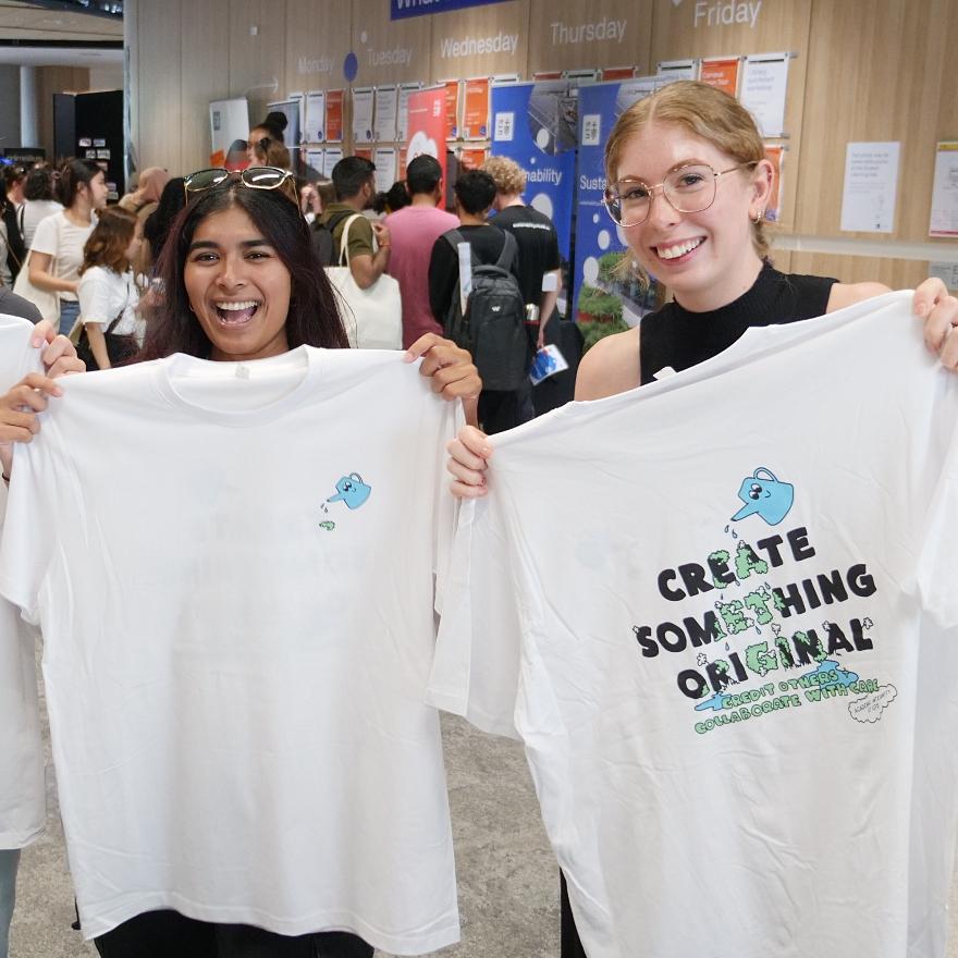 Students holding t-shirts, one which says 'Create Something Original'