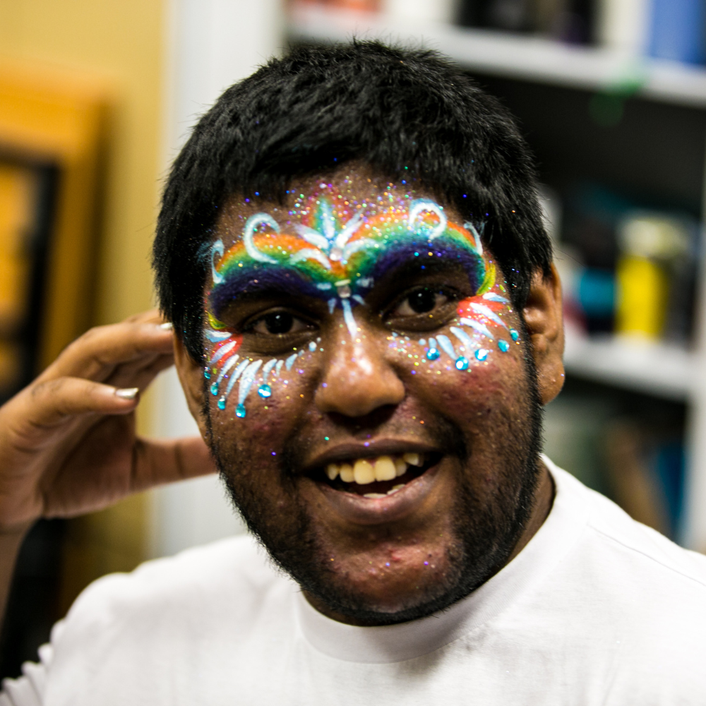 UTS student with rainbow paint on their face.