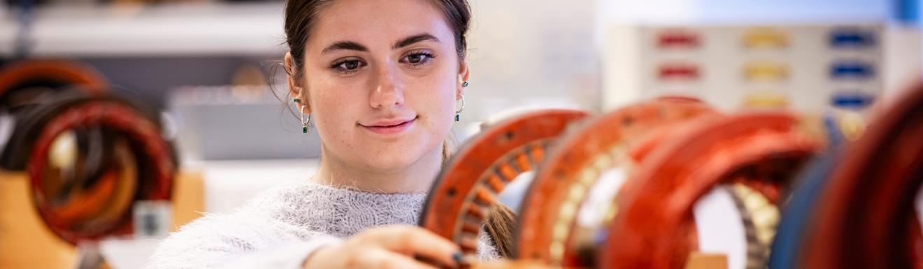 A student adjusts a series of cogs