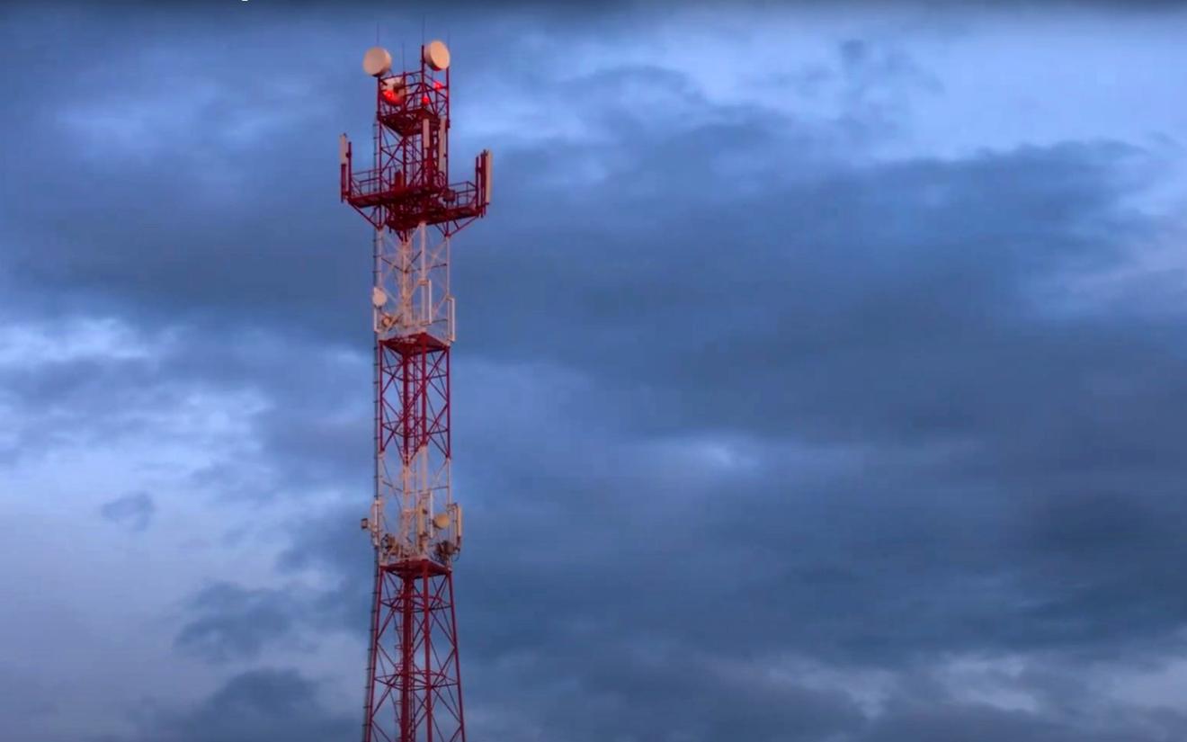 Screenshot from a UTS video of a mobile phone tower against a cloudy sky