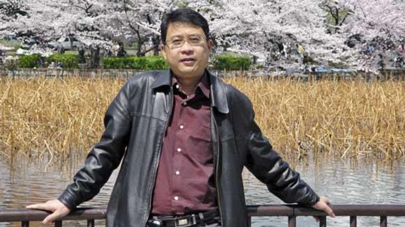 Dr Guandong Xu standing by a lake in China