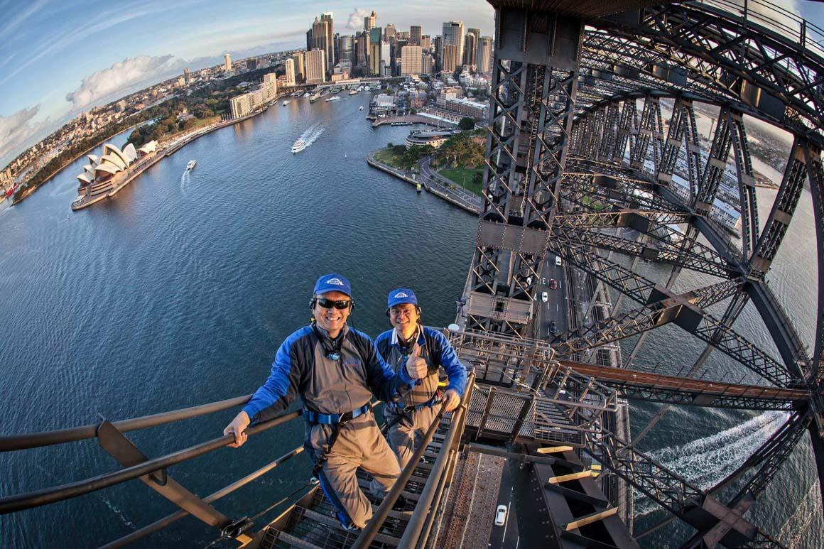 Two Chinese ‘incentive tourists’ climb the Harbour Bridge. Photo: courtesy BESydney
