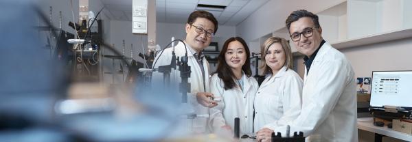 Four UTS scientists in lab posing for photo wearing labcoats