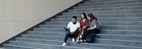 UTS students sitting on steps and working together outside campus