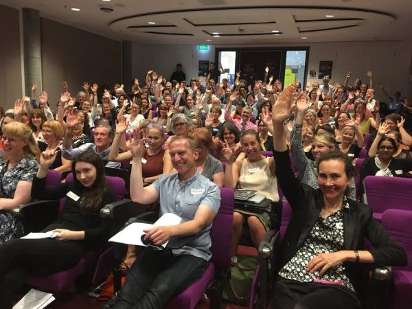 An image of the GLAMSLAM 2018 attendees smiling with their hands in the air.