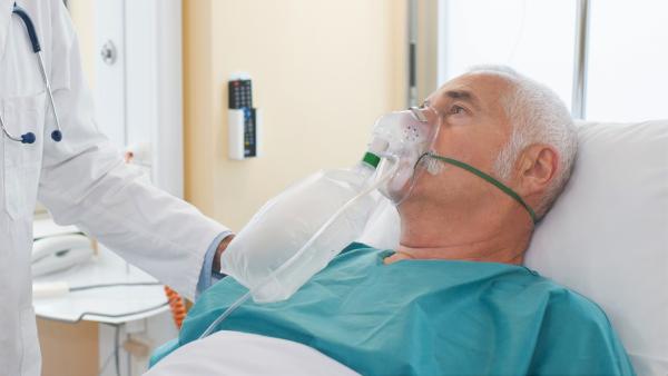 Man on oxygen mask. Image:  auremar / Adobe Stock