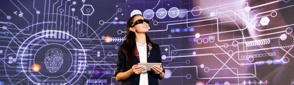 Female student wearing 3D glasses looking at data arena projections