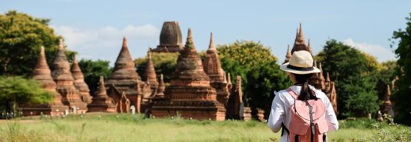 Young backpacker with hat looking at temples and pagoda in Myanmar.