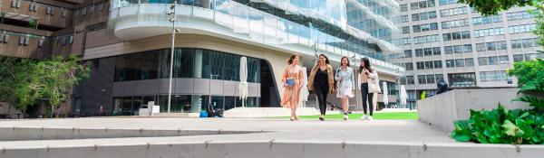 Four international students walking through university campus