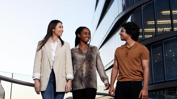 Three postgraduate students walking together on campus