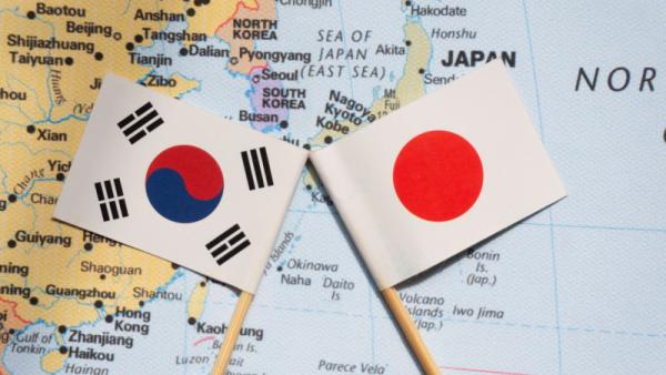 Japan and South Korea flags placed on a map of east Asia